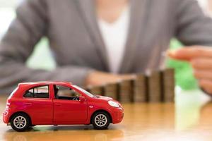 femme d'affaires une petite voiture et une pile de pièces photo