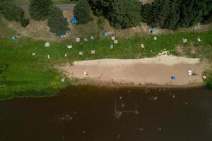 les gens se détendent et nagent sur la rive du fleuve vue d'en haut photo