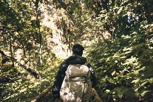 sac à dos photographe mâle adulte voyageant dans la forêt.