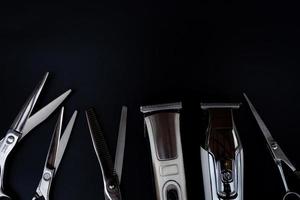 un ensemble d'outils de coupe de cheveux sur fond noir pour couper le salon de barbe de coiffeur photo