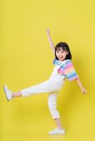 image pleine longueur d'un enfant asiatique posant sur fond jaune photo