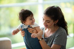 jeune mère et enfant bébé sont heureux à la maison, concept de famille d'enfance avec maman caucasienne et petit garçon, mode de vie des soins aux nouveau-nés photo