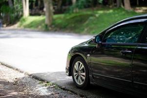 une voiture noire garée à côté de la forêt photo