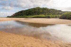 rivière qui se jette dans la plage de taipe près d'arraial d'ajuda, bahia, brésil photo