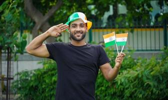jeune homme avec drapeau indien ou tricolore faisant le salut photo