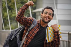 je réussis garçon avec livre et sac appréciant son succès photo