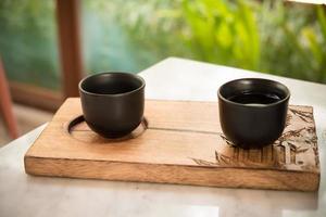 versez à la main du thé traditionnel chinois ou japonais à partir d'un pot en argile photo