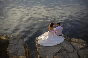 la mariée et le marié se promènent près du vieux château. le couple se tient dos à l'autre. photo