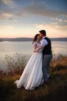 la mariée et le marié se promènent près du vieux château. le couple se tient dos à l'autre. photo