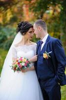 la mariée et le marié sur le fond du parc d'automne. photo