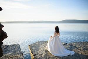 la mariée et le marié se promènent près du vieux château. le couple se tient dos à l'autre. photo