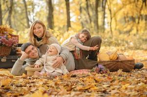 une famille avec deux filles est partie en pique-nique. temps de l'automne. photo