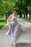 belle jeune femme posant dans une robe noire dans un parc. photo