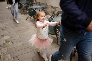 les parents et leur fille sont assis sur les marches d'une vieille église. photo