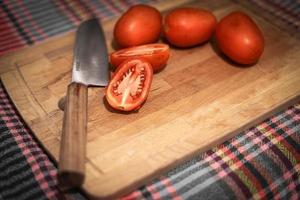 tomate à bord avec un couteau bien aiguisé photo