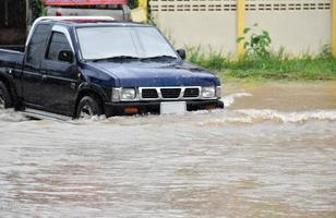 voiture de ramassage et véhicule dans les eaux de crue, assurance automobile et concept de situation dangereuse. photo