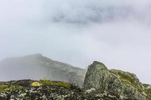 brouillard, nuages, rochers et falaises sur la montagne veslehodn veslehorn, norvège. photo