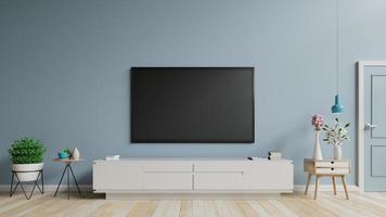 maquette de télévision intelligente sur armoire avec écran blanc suspendu avec plantes, étagère, lampe sur mur bleu.