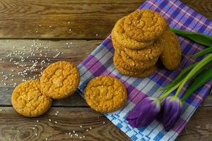 biscuits au sésame faits maison et deux tulipes violettes sur la serviette en lin photo