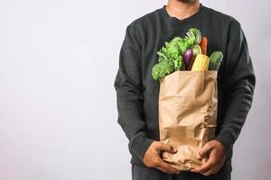 homme tenant un sac d'épicerie avec des légumes pour un concept de mode de vie sain photo