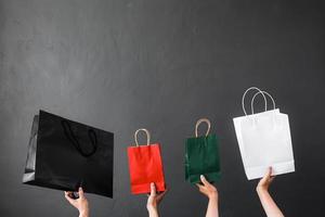 récolte de main tenant un sac à provisions ou un sac de cadeaux pour l'accro du shopping ou le fond de magasinage en ligne photo