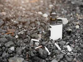 générateur de vapeur électronique sur fond de mégots de cigarettes photo