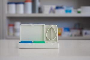 coupe-comprimé avec des étagères floues de médicaments dans le fond de la pharmacie de la pharmacie photo