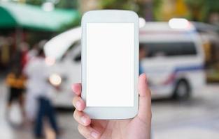 main tenir le smartphone avec une ambulance répondant à un appel d'urgence
