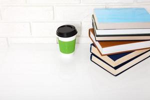 littérature éducative. tasse de café et livres sur la table dans une classe. vue de dessus et espace de copie. mise au point sélective photo