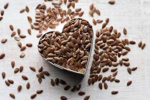 graines de lin brunes entières en forme de coeur photo