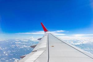 aile d'avion sur le ciel avec un beau ciel bleu et des nuages, vue aérienne depuis la fenêtre de l'avion. photo