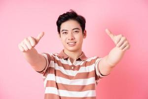jeune homme asiatique posant sur fond rose photo
