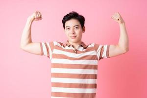 jeune homme asiatique posant sur fond rose photo