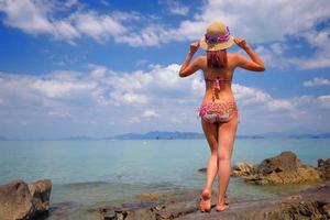 action libre et détente d'une fille bronzée en bikini sur une plage de sable blanc à krabi, en thaïlande. image conceptuelle pour les vacances d'été dans un pays tropical. photo