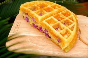 délicieuses gaufres saveur de patate douce violette sur la plaque de bois au jardin. photo