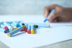 crayons de couleur sur papiers jaunes sur table photo