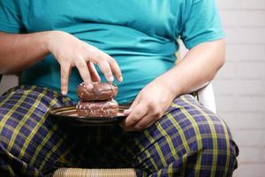 jeune homme mangeant des beignets, mise au point sélective photo