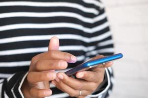 gros plan de la main du jeune homme à l'aide d'un téléphone intelligent. photo