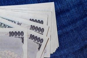 argent japonais, billet de banque japonais, yen sur fond de jean. photo