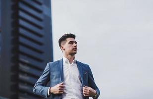 homme en costume contre un immeuble de bureaux photo