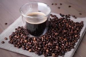 tasse en verre avec café et tas de grains de café torréfiés