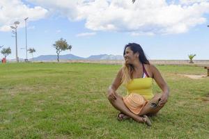 portrait d'une femme latine souriante, s'amusant, en vacances à Majorque posant par une chaude journée d'été de printemps, sous un palmier, concept de vacances photo