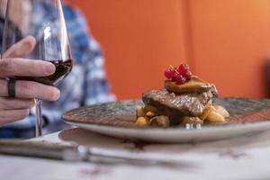 homme appréciant un délicieux dîner avec du vin à l'hôtel de villégiature photo