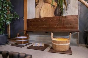 seaux de sauna en bois dans le centre de spa contre la peinture à l'huile accrochée au mur photo