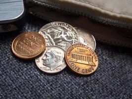 pièces en dollars américains placées à l'extérieur du portefeuille avec smartphone. photo