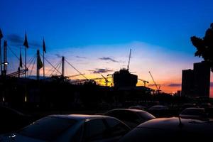 grues de construction industrielle et silhouettes de bâtiments au coucher du soleil photo