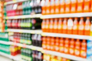 bouteilles de boissons gazeuses sur des étagères dans un arrière-plan flou de supermarché photo