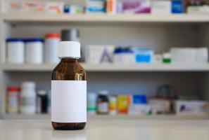 étiquette blanche vierge de flacon de médicament avec des étagères floues de médicament dans l'arrière-plan de la pharmacie de la pharmacie