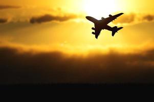 silhouette d'un avion de passagers décollant de l'aéroport le soir. photo