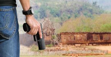 Pistolet automatique de 9 mm tenant dans la main droite du tireur, concept de sécurité, vol, gangster, garde du corps dans le monde entier. mise au point sélective sur le pistolet. photo